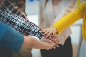 Group of Multiracial people putting their hands working together showing oneness symbol. photo
