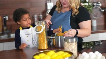 Young girl and adult woman in kitchen preparing food4k 29fp video