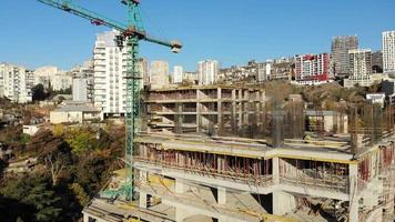 vista panorámica aérea del sitio de construcción con material de bloque de transporte de grúas y trabajadores trabajando. sitio inmobiliario en saburtalo, tbilisi, georgia video