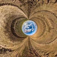 blue sky ball in middle of swirling asphalt road or field. Inversion of tiny planet transformation of spherical panorama 360 degrees. Spherical abstract view. Curvature of space. photo