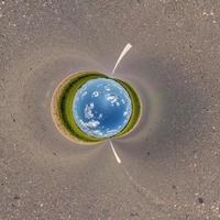 blue sky ball in middle of swirling asphalt road or field. Inversion of tiny planet transformation of spherical panorama 360 degrees. Spherical abstract view. Curvature of space. photo