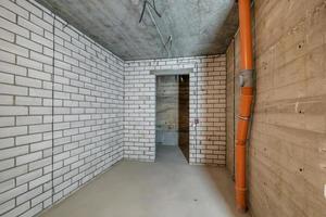 Empty basement room with minimal preparatory repairs. interior with white brick walls photo