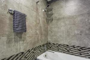 water tap sink with faucet in expensive loft bathroom. detail of a corner shower cabin with wall mount shower attachment photo