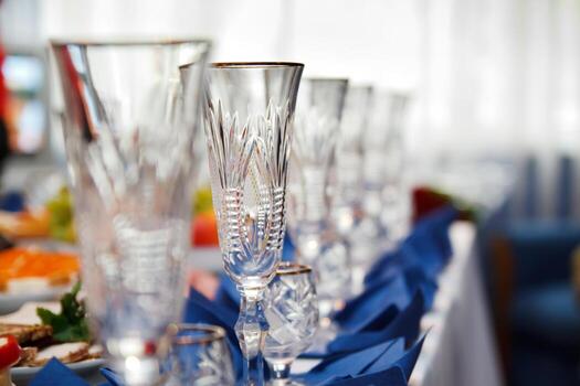 mesa de banquete servida con instrumentos y decorada con una fila de copas de vino vacías foto