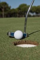 golpear la pelota de golf en el hoyo foto