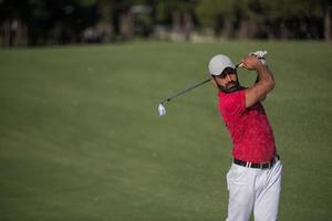 golfer hitting a sand bunker shot photo