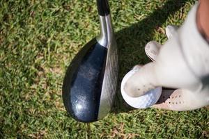 golf player placing ball on tee photo
