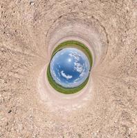 Blue little planet among white sand. Inversion of tiny planet transformation of spherical panorama 360 degrees. Spherical abstract aerial view. Curvature of space. photo