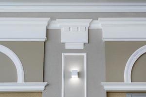 Detail of corner ceiling with intricate crown molding on column with spot light photo