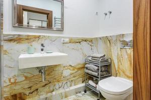 detalles de cabina de ducha de esquina con accesorio de ducha de montaje en pared y lavabo con grifo en baño caro foto