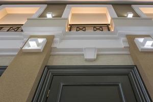 Detail of corner ceiling with intricate crown molding on column with spot light photo