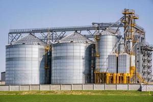 Modern Granary elevator. Silver silos on agro-processing and manufacturing plant for processing drying cleaning and storage of agricultural products, flour, cereals and grain. seed cleaning line photo