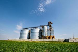 Modern Granary elevator. Silver silos on agro-processing and manufacturing plant for processing drying cleaning and storage of agricultural products, flour, cereals and grain. seed cleaning line photo