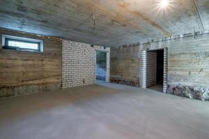 Empty basement room with minimal preparatory repairs. interior with white brick walls photo