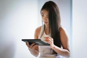 nueva normalidad, una mujer de negocios que usa una tableta para trabajar para una empresa a través de Internet en su escritorio en casa. foto