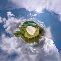 pequeño planeta en el cielo azul con sol y hermosas nubes. transformación de panorama esférico 360 grados. vista aérea abstracta esférica. curvatura del espacio. foto