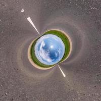 Blue little planet on asphalt road. Inversion of tiny planet transformation of spherical panorama 360 degrees. Spherical abstract aerial view. Curvature of space. photo