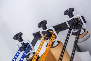 mounting manual support system for photo backdrops in modern studio. Rolls of colorful paper backgrounds for photo studio hang on the wall