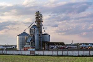 ascensor de granero moderno con silos de plata en la planta de procesamiento y fabricación de productos agrícolas para el procesamiento, secado, limpieza y almacenamiento de productos agrícolas, harina, cereales y granos. foto