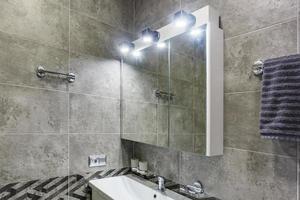 water tap sink with faucet in expensive loft bathroom. detail of a corner shower cabin with wall mount shower attachment photo