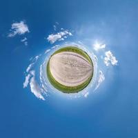 tiny planet transformation of spherical panorama 360 degrees. Spherical abstract aerial view in field with clear sky and awesome beautiful clouds. Curvature of space. photo