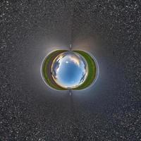 bola de cielo azul en medio de una carretera o campo de asfalto giratorio. inversión de la transformación del pequeño planeta del panorama esférico de 360 grados. vista abstracta esférica. curvatura del espacio. foto