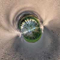 Inversion of blue little planet transformation of spherical panorama 360 degrees. Spherical abstract aerial view on field with awesome beautiful clouds. Curvature of space. photo