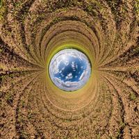 Inversion of blue little planet transformation of spherical panorama 360 degrees. Spherical abstract aerial view on road with awesome beautiful clouds. Curvature of space. photo