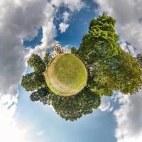 tiny planet with road in blue sky with beautiful clouds. Transformation of spherical panorama 360 degrees. Spherical abstract aerial view. Curvature of space. photo