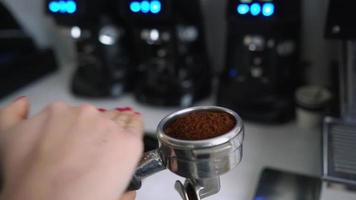 gros plan sur les mains d'un barista tapotant un porte-filtre expresso moulu video