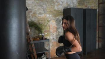 cámara lenta de mujer golpeando saco de boxeo con guantes de boxeo video