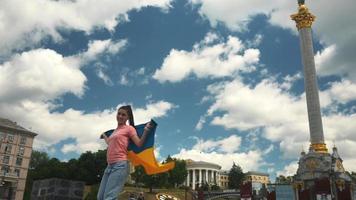 mujer joven sostiene y ondea la bandera de ucrania en el centro de Kyiv video