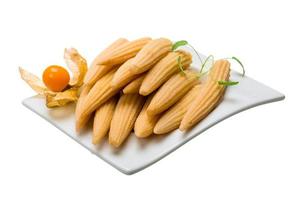 Baby corn in a bowl on wooden background photo