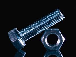 Iron bolt and nut on black background with reflexion photo