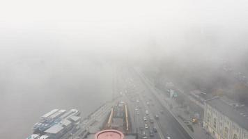 Cars travel on road near Dnieper River in dense fog Kyiv, Ukraine video