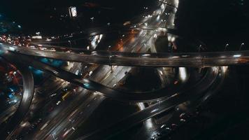 Aerial panning out time-lapse of busy city traffic on overpass at night video