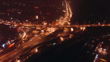 Moving aerial time-lapse of busy city traffic on overpass at night video