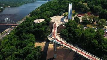 Aerial zoom on pedestrian bridge in Kyiv Ukraine with view of The Arch of Freedom monument video