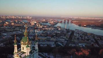 Aerial view of St Andrews Church with orange trees in fall and city Kyiv, Ukraine on horizon video