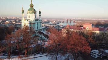 Aerial view of St Andrews Church with orange trees in fall and city Kyiv, Ukraine on horizon video