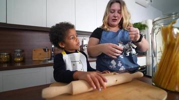 Young girl and adult woman in kitchen making cookies video