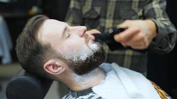 Barber towels shaving cream from man's face
