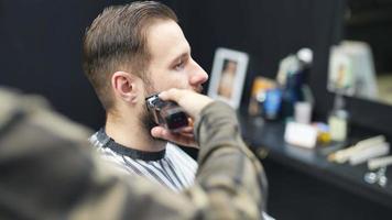 friseur schneidet die haare des männlichen kunden mit kamm und schermaschine video