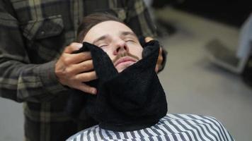 barberare handdukar mannens skägg och ansikte torr efter rakning video