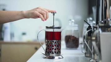 French press pushed down after loose leaf tea is steeped in hot water video