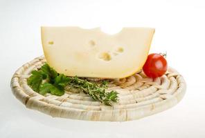 Maasdam cheese on wooden plate and white background photo