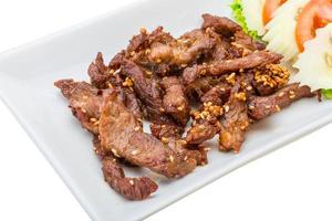 Fried pork thai style on the plate and white background photo