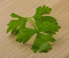 Celery leaves on wooden background photo