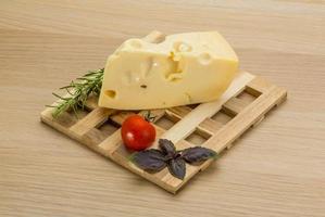 Maasdam cheese on wooden background photo
