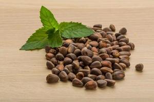 Cedar nuts on wooden background photo